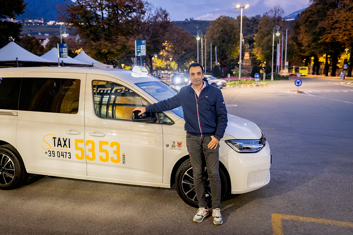 Taxi Merano driver next to a taxi vehicle, representing real-time data sharing for smart and multimodal mobility services.