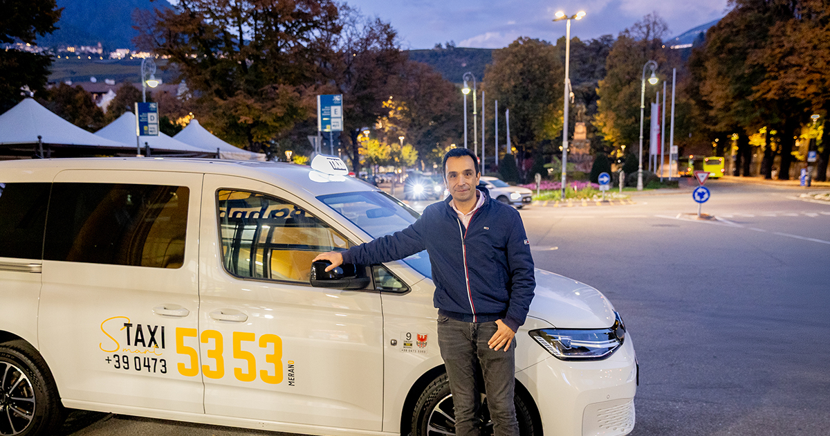 Taxi Merano driver next to a taxi vehicle, representing real-time data sharing for smart and multimodal mobility services.