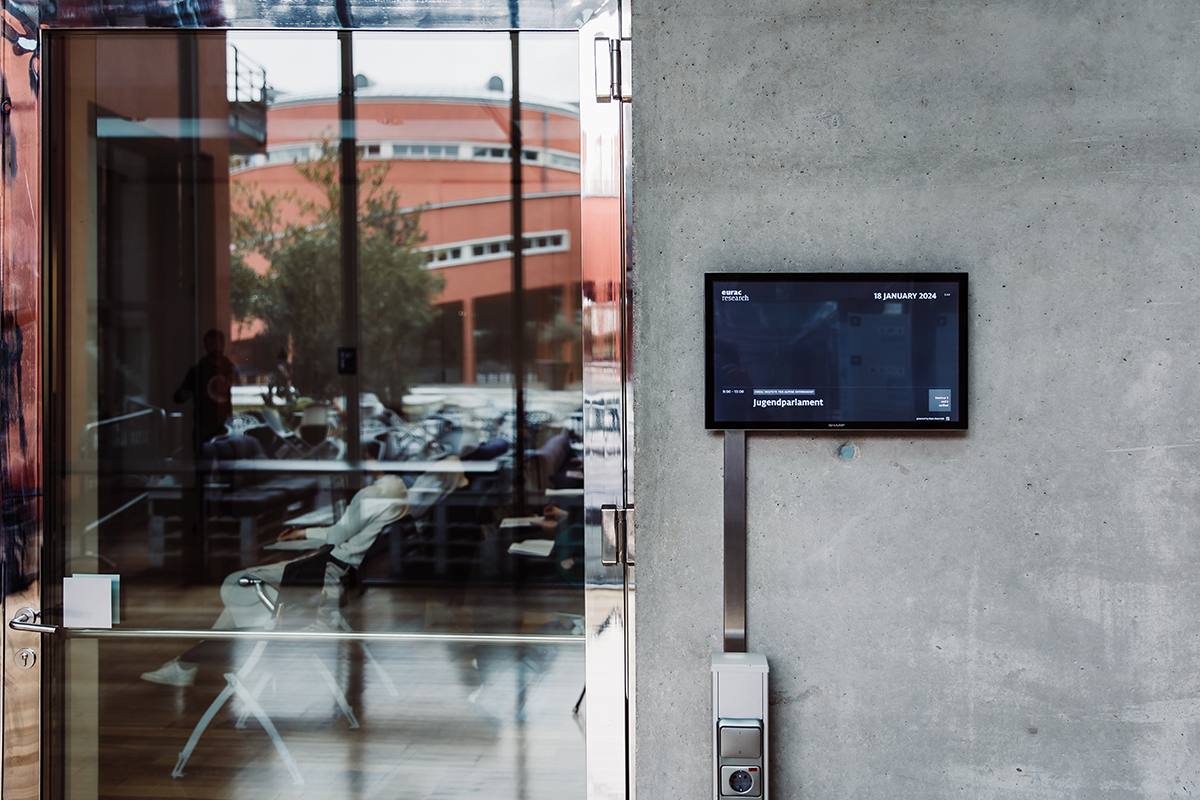 Screens at Eurac Research displaying events, enhanced by Open Data Hub's data visualization services.